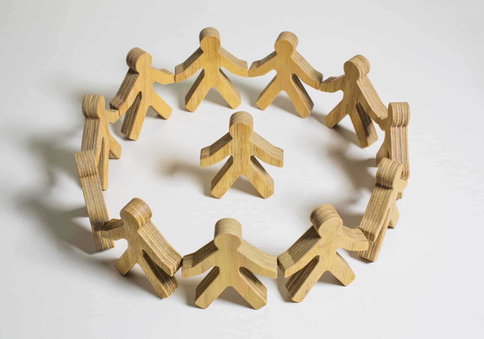 Wooden Model Men In A Circle, One In Centre